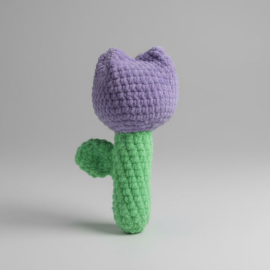 Handmade crochet Purple Tulip on a gray quilted surface