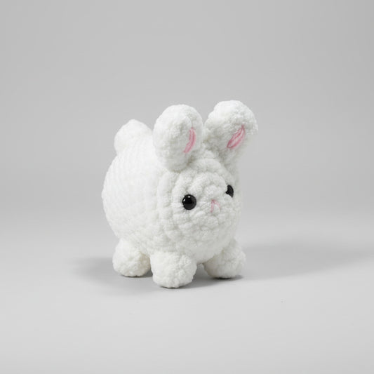 Small white handmade crochet rabbit toy in a white background