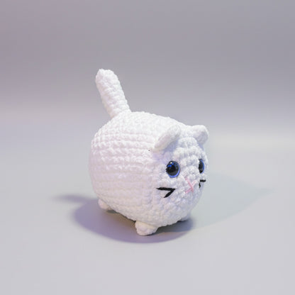 White plush crochet cat with blue eyes on a light gray background